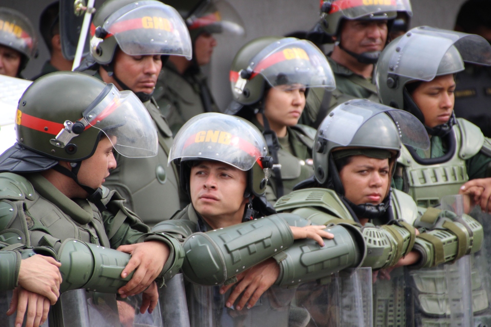 Soldiers guarding a the Merida offices of Venezuela's electoral commission following the 14 April elections. Most of these troops were only armed with riot shields, while opposition supporters protesting the election results rallied outside the offices. Many of the protesters brought Molotov cocktails, knives, baseball bats and other weapons. Minutes after this photograph was taken, opposition protesters clashed with Chavistas, who had gathered to hold a rally of their own a few hundred metres down the road. Some of the Chavistas were similarly armed, but poorly equipped police broke up the violence without appearing to harm anyone themselves. Protesters soon moved to side streets, where they repeatedly clashed out of sight from authorities. In the international media, these opposition protests were generally depicted as peaceful rallies being crushed by government forces. The reality on the ground was a little more complicated.